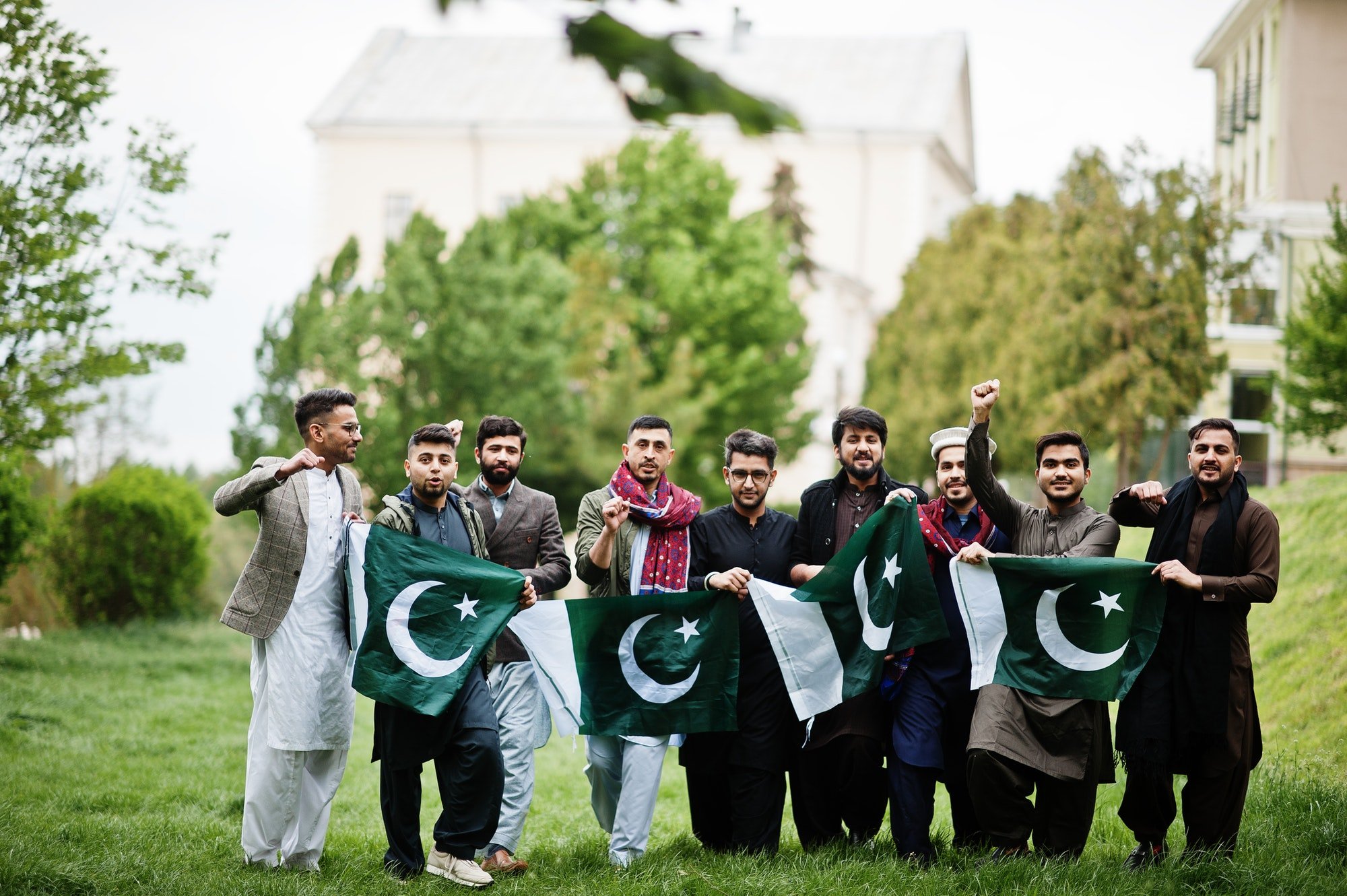 Group of pakistani man wearing traditional clothes salwar kameez or kurta with Pakistan flags.